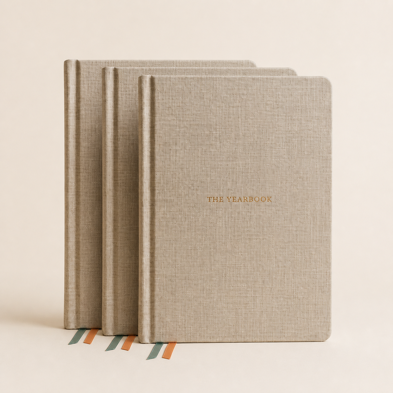 Three copies of The Yearbook 2027 annual planner in a warm studio product photo.